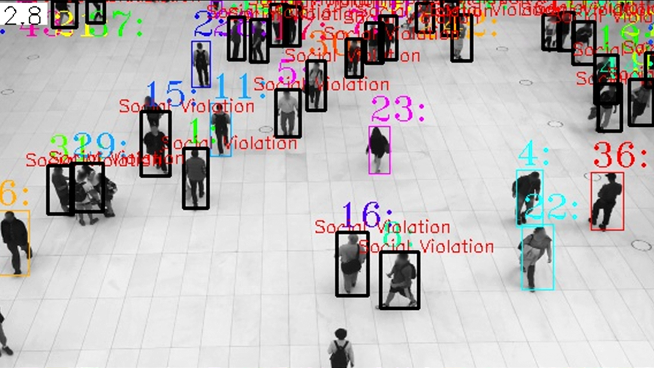 Screenshot of many people walking in a building. Some of red bounding boxes surrounding them that say "social violation" and others have blue boxes surrounding them. 