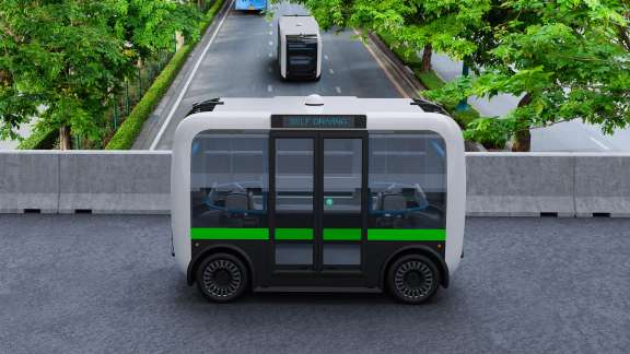 自动驾驶的电动穿梭巴士穿越城市绿道。